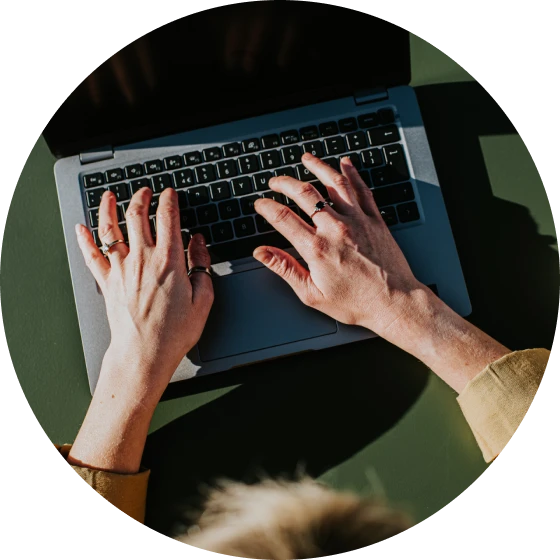 Aerial view of hands typing on laptop keyboard