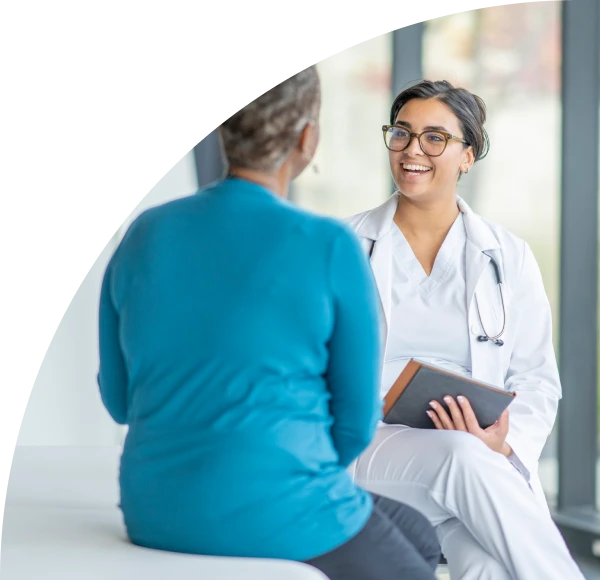 Female healthcare professional laughing and talking with patient