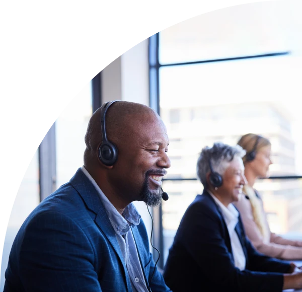 Three customer service representatives with telephone headsets on, smiling