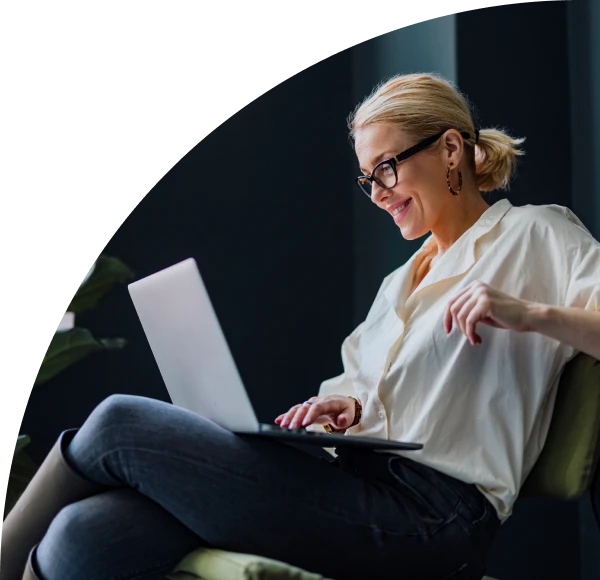 Woman seated in chair in business casual attire using laptop computer