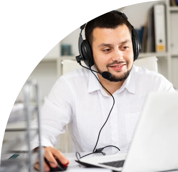 Man on telephone headset, working on laptop computer